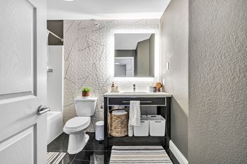 A bathroom with a toilet sink and a mirror